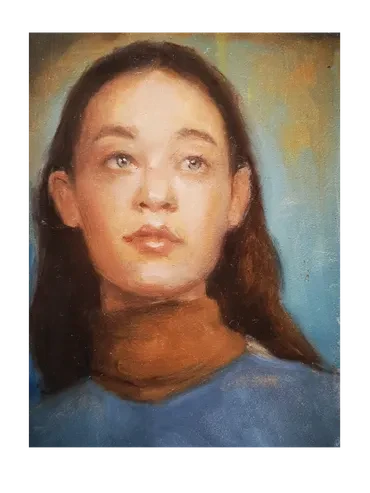 Portrait of a young girl in a blue top looking upward