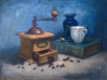 Still life with a vintage coffee grinder, blue vase and books